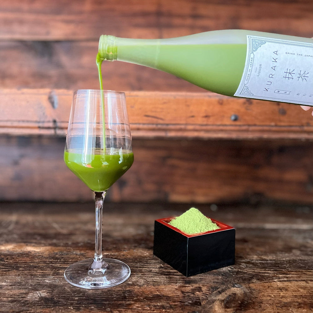 
                  
                    Sake al Matcha Kuraka 720ml | Todoku Japan. Servito nel bicchiere dalla bottiglia, con polvere di tè matcha vicino
                  
                