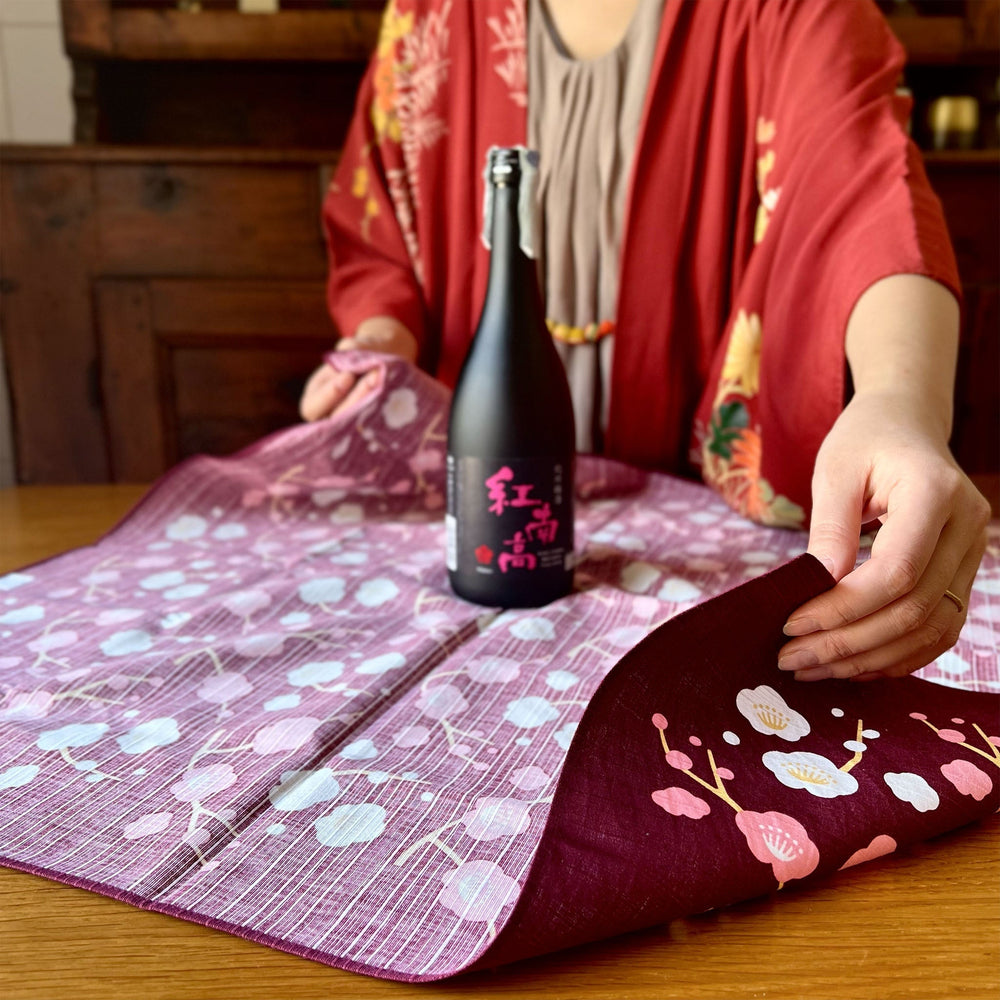 
                  
                    Furoshiki Fiori Di Prugna Ume - Miyamoto (70 x 70 cm) | Todoku Japan. Megumi incarta con Furoshiki bottiglia di Umeshu.
                  
                